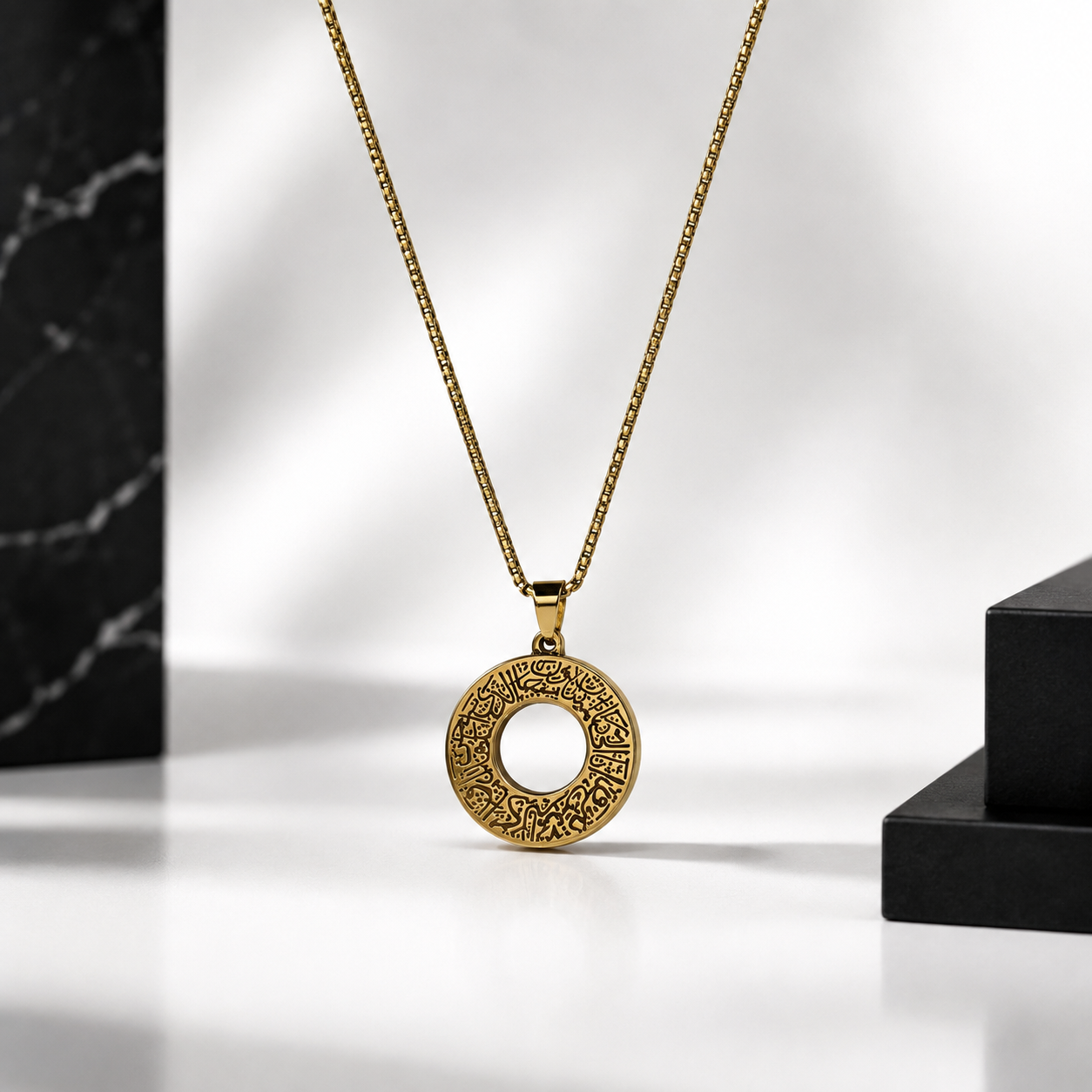 A gold ayat al kursi pendant for men necklace with an intricate circular filigree design, hanging from a gold chain