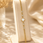 Shop an elegant gold clover bracelet for women in Qatar, featuring a white floral charm and sparkling crystal accents. Perfect for everyday wear and gifting.