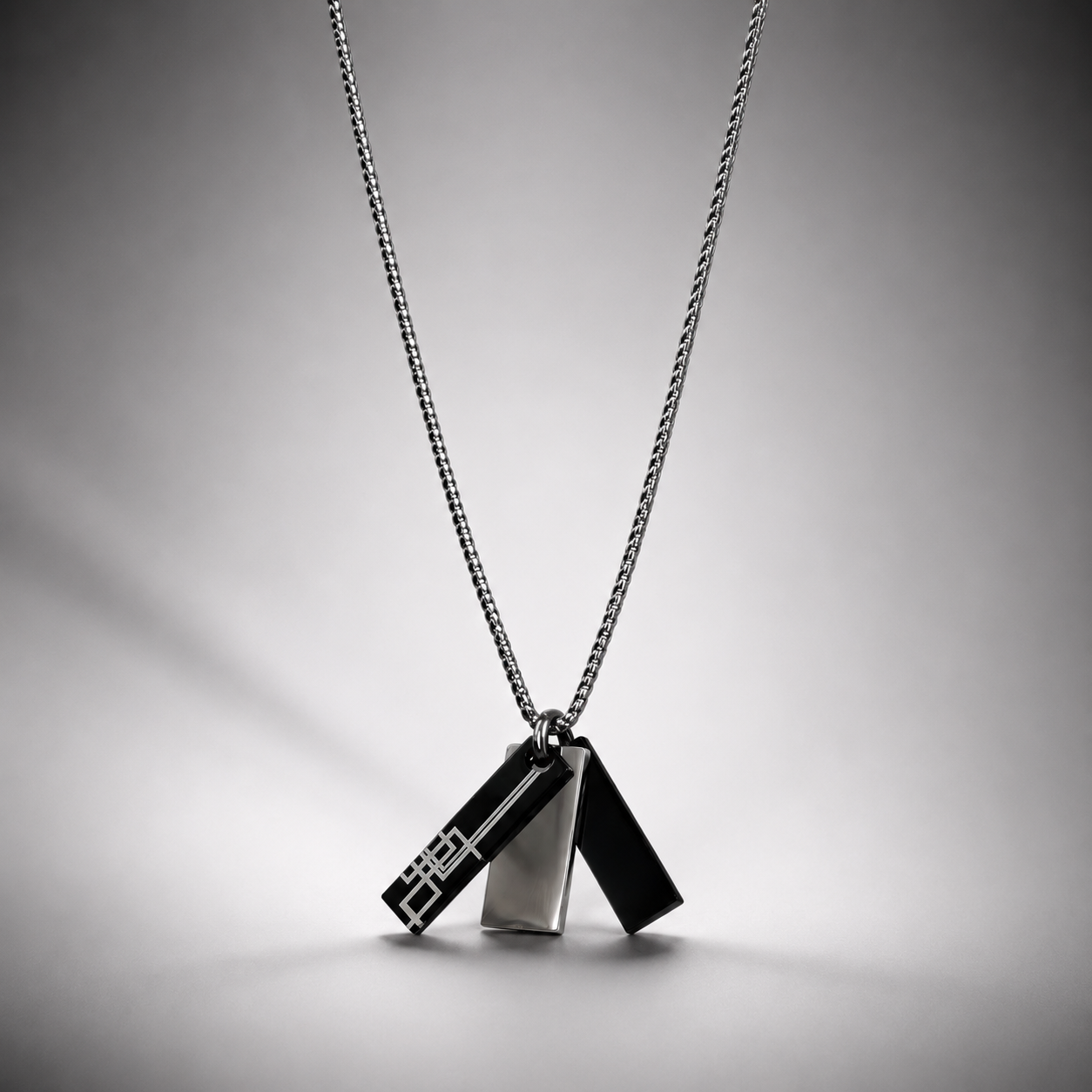 A silver-toned geometric 3 pendant for men necklace on a fine chain, featuring two interlocking triangular charms with a modern angular design in qatar