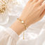 Shop an elegant gold clover bracelet for women in Qatar, featuring a white floral charm and sparkling crystal accents. Perfect for everyday wear and gifting.