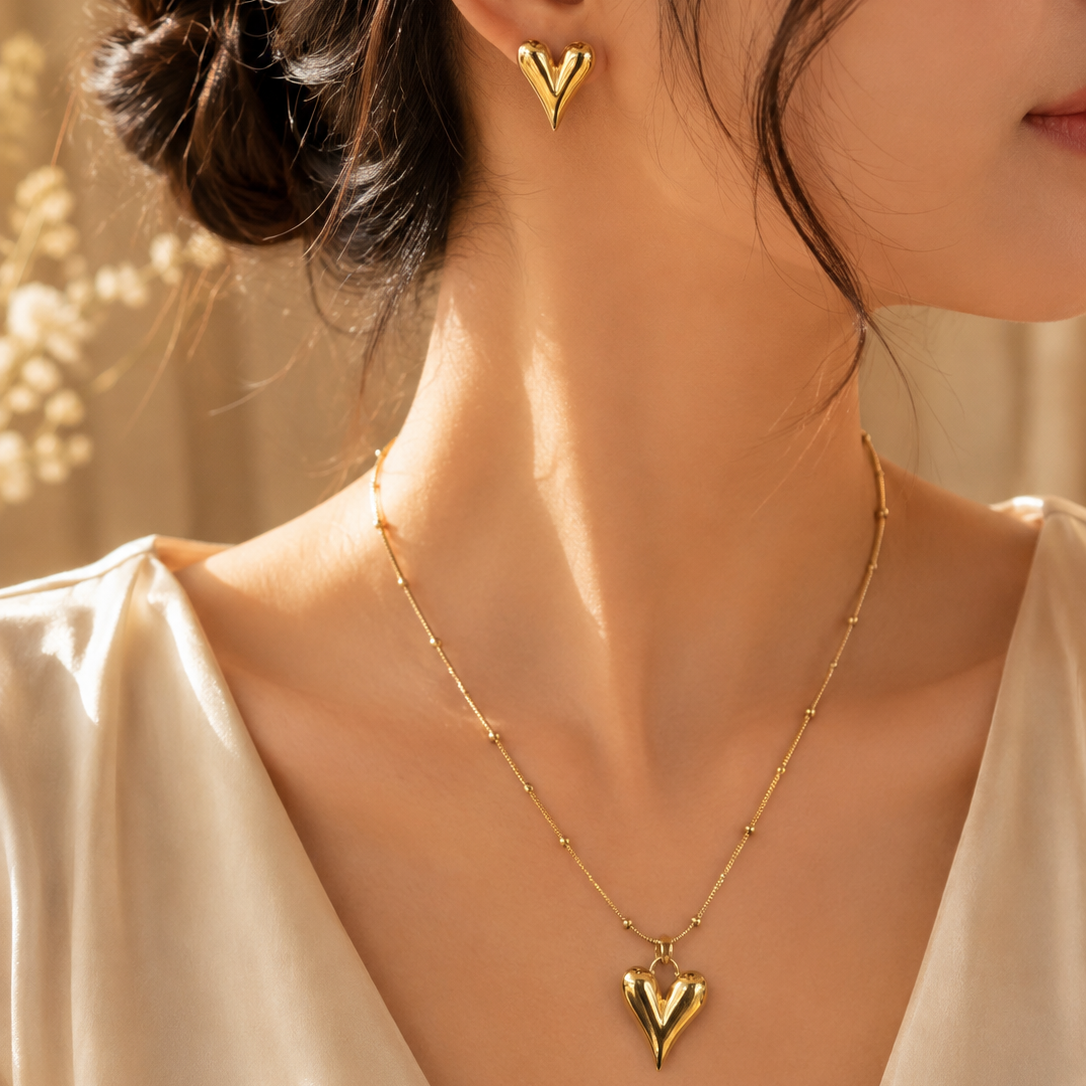 Woman wearing a premium stainless steel gold heart necklace and matching heart earrings